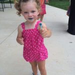 young girl holding lolipop