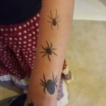 Girl with spider tattoos on her arms
